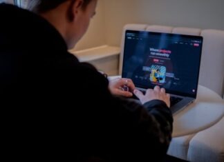 a person sitting at a table with a laptop