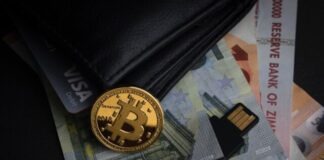 a bitcoin sitting on top of a pile of money