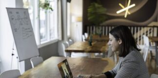 woman in gray and white striped long sleeve shirt using silver macbook