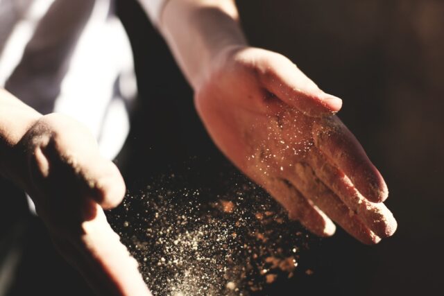 Photo by Austin Ban person's hand with dust during daytime