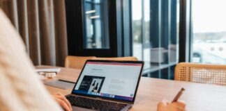 a person sitting at a table with a laptop