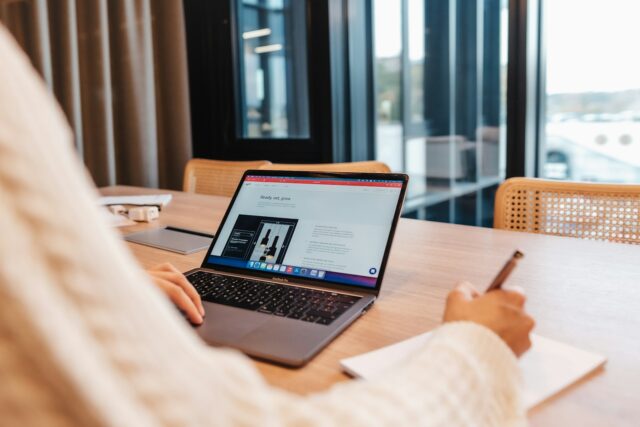 Photo by Zyro a person sitting at a table with a laptop