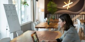 woman in gray and white striped long sleeve shirt using silver macbook