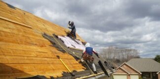a couple of men working on a roof