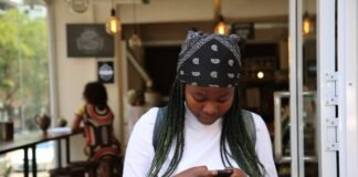 woman standing while holding black phone