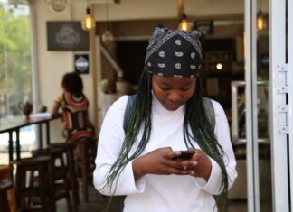 woman standing while holding black phone