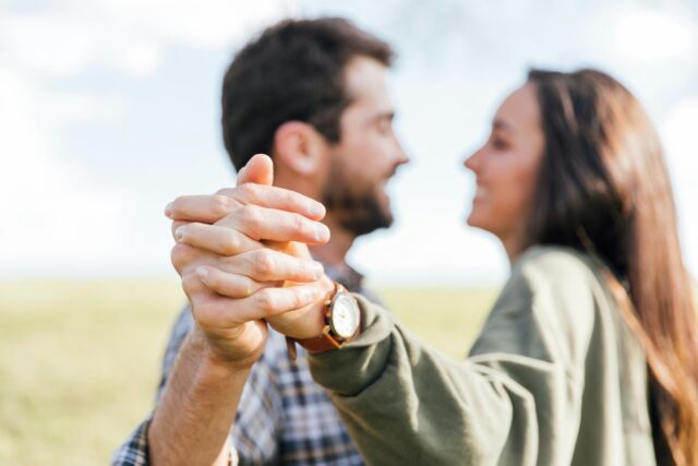 Photo by Katy Anne man in gray long sleeve shirt holding womans hand