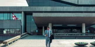 man walking while holding black coat