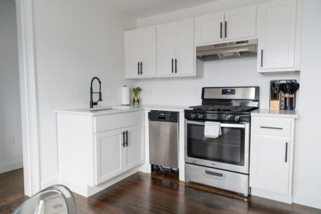 Photo by Andrea Davis white wooden kitchen cabinet and white microwave oven
