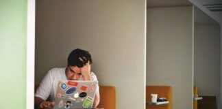man wearing white top using MacBook