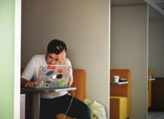 5 Things to Do if You’re Struggling with Debt man wearing white top using MacBook