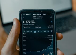 a person holding a cell phone in front of a laptop