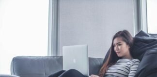 woman sitting on sofa while using MacBook Pro
