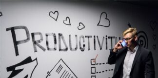 man holding smartphone looking at productivity wall decor