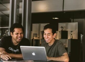 Benefits of Employee Monitoring two smiling men looking at MacBook