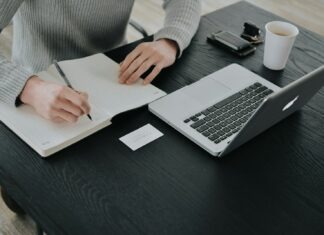 person in white dress shirt holding white paper