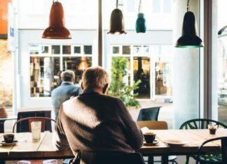 In Home Care vs Assisted Living: Which Option is Best for You? man in chair with table beside coffee