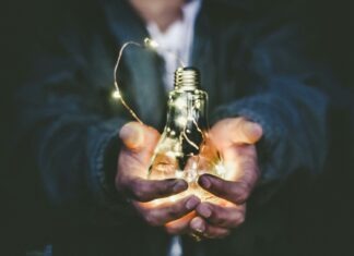 man holding incandescent bulb