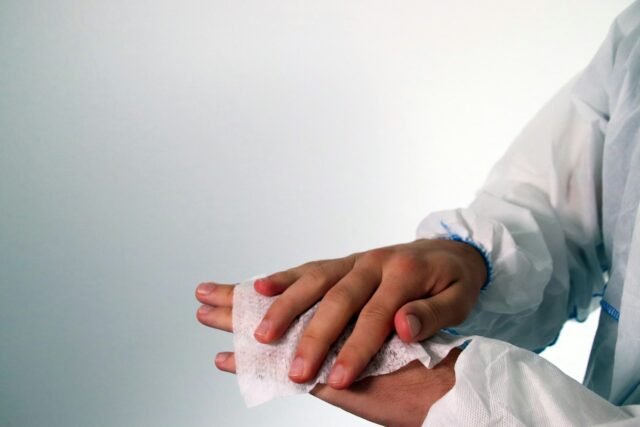 Photo by Maskmedicare Shop person in white long sleeve shirt holding white tissue paper