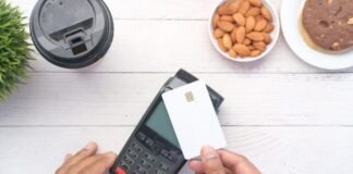 a person holding a credit card next to a calculator