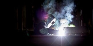 person welding metal using gray helmet
