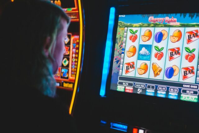 Photo by Erik Mclean man playing slot machine game