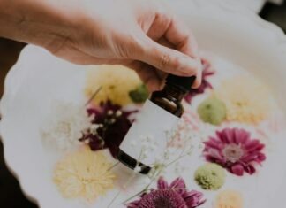 Jojoba Olie Is Conquering the Beauty and Wellness Industries person holding bottle