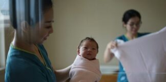 woman carrying newborn baby