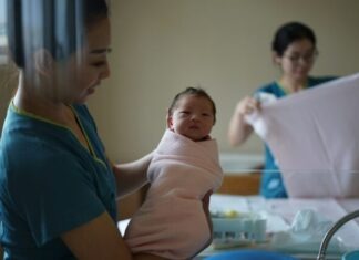 woman carrying newborn baby