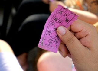 Top Guide for Playing Bingo a person holding a pink ticket in their hand