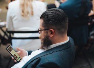 Top Rated Sweepstake Casino Review Sites That Also Review Social Sportsbooks a man sitting in a chair looking at his cell phone