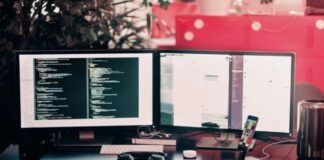 two black computer monitors on black table