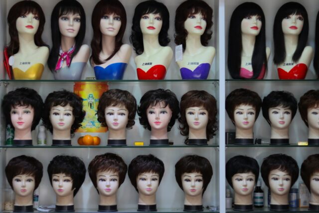 Photo by Taha a display case filled with lots of mannequin heads