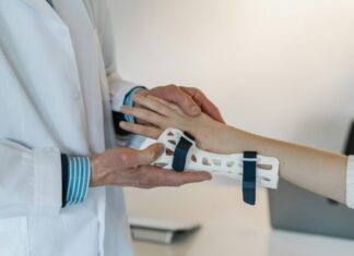 person in white coat holding silver and blue ring