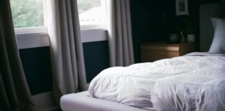 white bed by the window during daytime