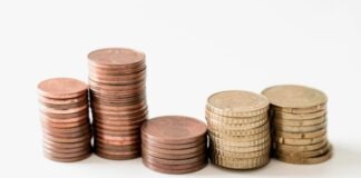 stacked round gold-colored coins on white surface
