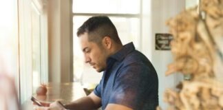 man in black button-up shirt holding smartphone