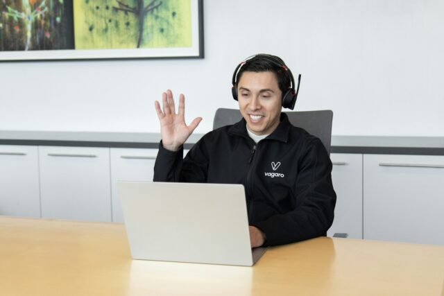 Photo by Vagaro a man wearing headphones sitting in front of a laptop computer