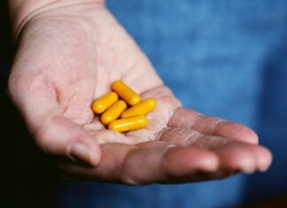 Steps to Success: Choosing a Reliable Manufacturer of Dietary Supplements yellow medication pill on persons hand