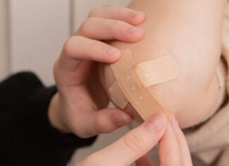 person holding band aid on left hand