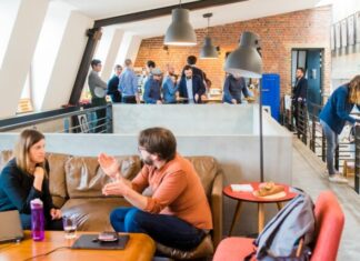 6 Tips for a Safer Workplace man in orange dress shirt talking and sitting in front of woman on brown sofa