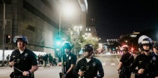 man in black shirt and pants holding black dslr camera