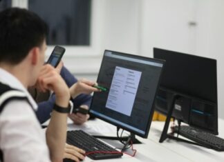 How to Use Open Source Code Responsibly A group of people sitting at a table with computers