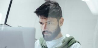 man facing MacBook Pro