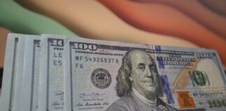 a stack of twenty dollar bills sitting on top of a table