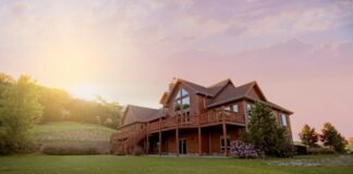 brown wooden house with green grass field