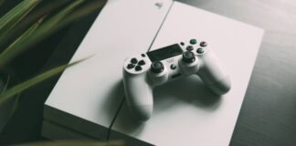selective focus photography of white Sony PS4 console with wireless controller