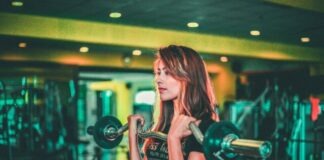 woman lifting black and gray barbell