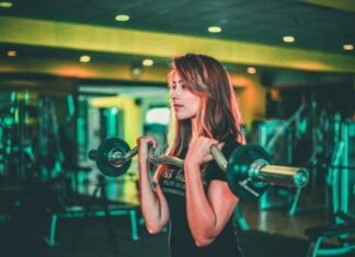 The Daily Routine of a Fitness Model on OnlyFans woman lifting black and gray barbell