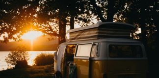 a van parked on the side of a road with a sunset in the background